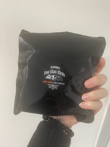 Customer holding the black packaging for the Candy Corn & Oreo Cookies Duo Wax Melts.