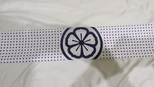 Customer's folded Karate Kid Tenugui headband, showing the central flower logo and dot pattern.