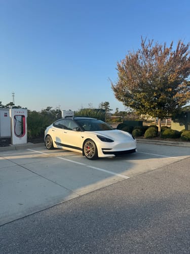 Customer's clean and shiny white car parked at a charging station, demonstrating the results of the Detail Spray.