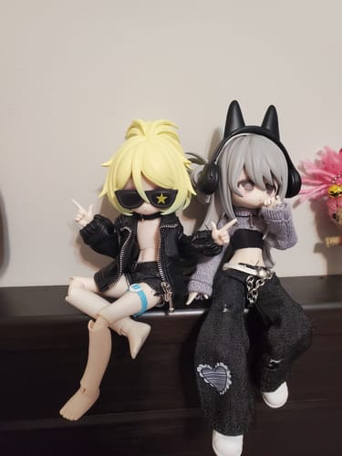 Customer's two stylish Ten Thousand Escape Plans action figures posed sitting together on a dark surface.