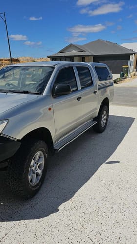Customer's clean, shiny silver 4WD truck parked in a sunny driveway after using the care package.
