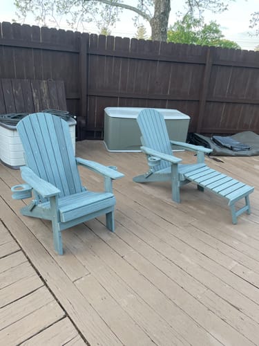 Customer's two light blue Folding Adirondack Chairs on a deck. One chair has the built-in footrest extended.