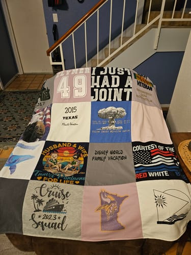 Customer's Project Repat T-Shirt Quilt draped over a chair, featuring personal t-shirts with vacation and sports logos.