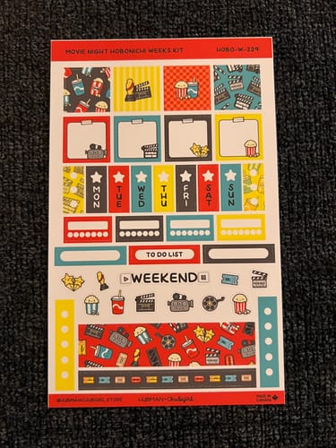 Customer's complete sticker sheet for the Movie Night Hobonichi Weeks Kit, laid on a dark surface.