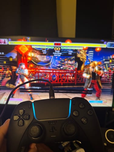 レビューアーが青いライトのボイドコントローラーを手に持ち、ゲームをプレイしている様子。