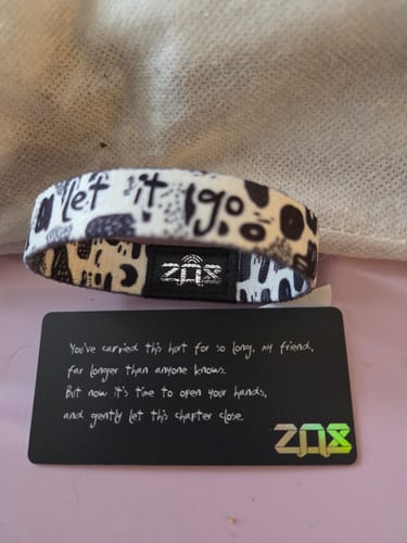 Customer's "Let It Go" affirmation bracelet from the Mental Health Pack, shown with its collector's card.