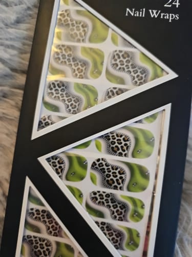 Kunde zeigt die 'Out On The Town' Nagelfolien in der Verpackung mit Leoparden- und Limettendesign.