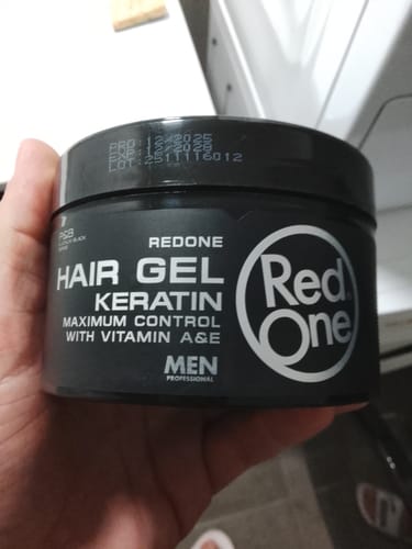 Customer holding a black tub of Redone Hair Styling Gel Keratin.
