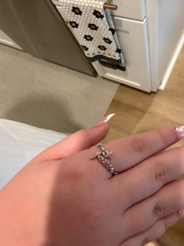 Customer's hand wearing the adjustable silver Faith Ring on their finger.