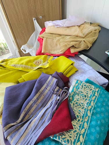 Reviewer's colorful fabric bundle showing a mix of embroidered teal, purple, and yellow materials.