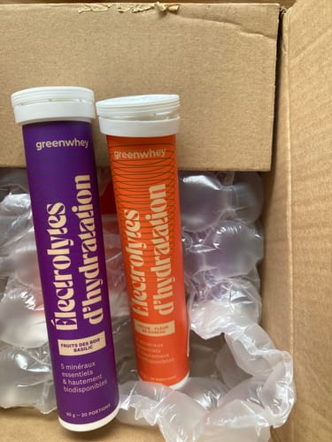 Photo d'un client montrant deux tubes d'Électrolytes d’hydratation, un violet et un orange, dans une boîte.