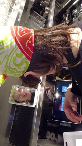 Customer wearing the vibrant Salad Bandana on their head in a commercial kitchen.