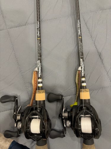 Reviewer's two black Waterloo Carbon Mag fishing rods with reels and lures attached, lying side-by-side.