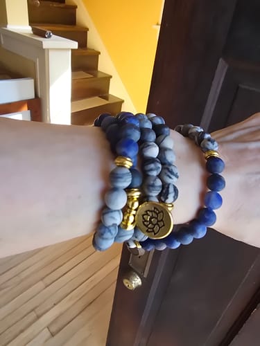 Reviewer's wrist wearing the Buddha Stones Mala bracelet, showing the varied blue Sodalite and marbled Zebra Jasper beads.