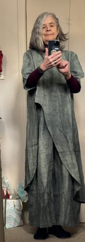 Reviewer in a mirror selfie wearing the dark, loose linen suit, styled with a long-sleeve shirt underneath.
