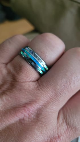 Close-up of a customer wearing the Vanguard ring, showcasing its detailed abalone and blue opal inlays.