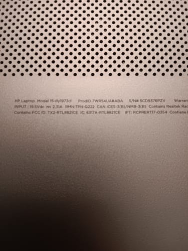 Close-up from a reviewer of the back of a silver HP laptop, showing the model information.