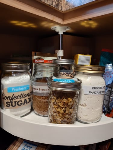 Reviewer's organized pantry showing various dry goods sealed in labeled mason jars on a white lazy susan.
