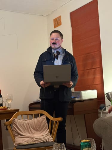 Reviewer in costume with a fake mustache playing the wine tasting murder mystery game.