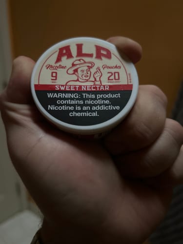 Customer holding a white can of Sweet Nectar Nicotine Pouches in their hand.