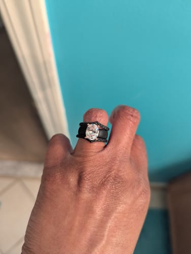 Reviewer's hand wearing the black Silicone Ring Stackable Set with a large oval CZ stone.