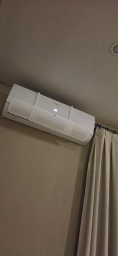 Foto de un cliente del Deflector Disperser blanco instalado en un aire acondicionado de pared.