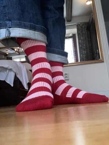 Anmelder med rød- og lyserødstribede støttestrømper på indendørs.