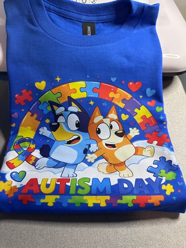 Customer's blue t-shirt with a colorful cartoon design for Autism Day, made using the DTF transfer film.