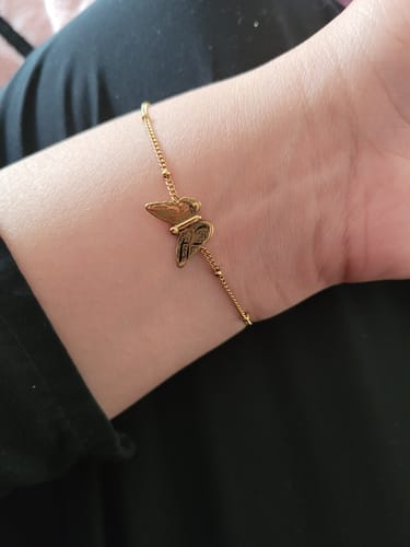 Close-up of a customer wearing the gold-tone Patience & Hope butterfly bracelet on their wrist.