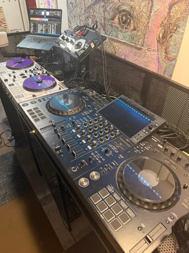 Customer's Model-X 2.0 Stand holding a laptop and mixer as part of a large DJ setup.