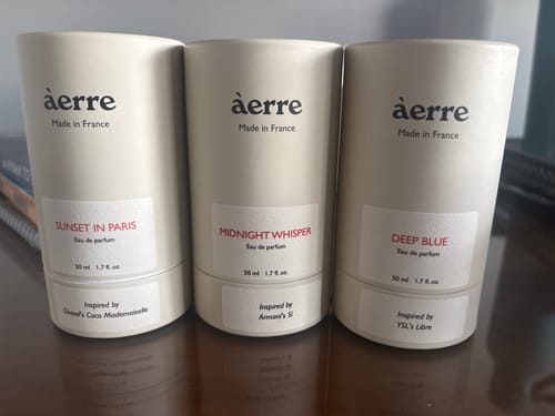Customer's three beige perfume tubes from Àerre, including Deep Blue, standing together on a table.