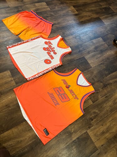 Reviewer's custom double-sided basketball jersey, showing both the orange and white sides, next to matching shorts.
