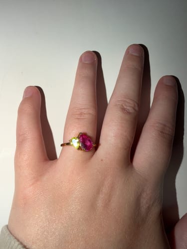 Customer wearing the Leesha Birthstone Ring with pink and green pear-cut stones on their finger.