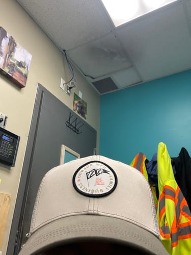 Reviewer in a close-up shot wearing a light-colored Big Trucker Hat indoors.