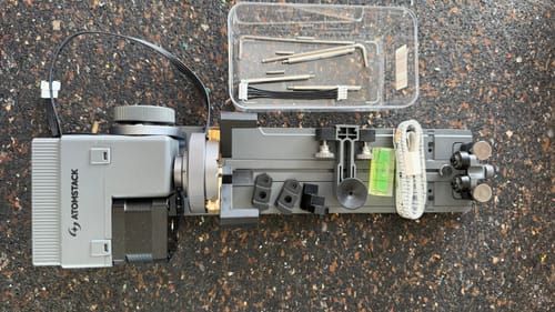 Customer's AtomStack R8 Rotary Chuck laid out horizontally with its complete accessory kit.