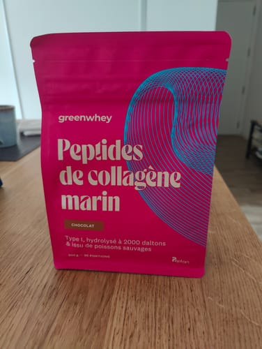 Sachet de Peptides de collagène marin au chocolat d'un client, posé sur une table en bois.