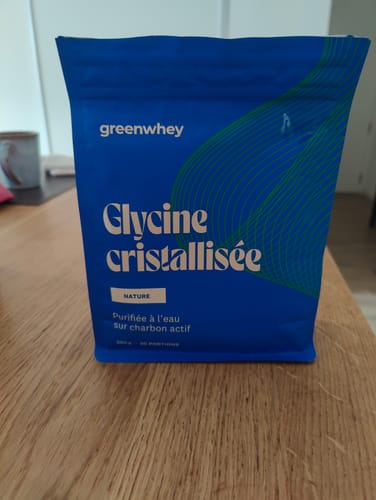 Avis d'un client : le sachet bleu de Glycine cristallisée posé sur une table en bois.