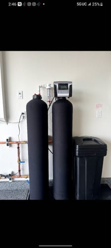 Customer's black SoftPro® Elite HE Water Softener system installed in a utility room.