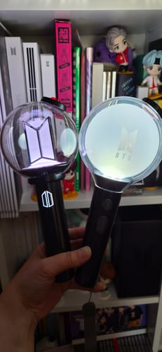 Customer holding the new BTS Official Light Stick Ver.4 next to an older model for comparison.