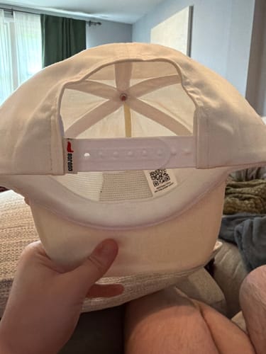 Reviewer holding the Big Flat Bill Unstructured Rope Hat, showing the inside and the white soft snapback.