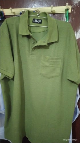 Customer's forest olive Waffle Polo T-Shirt from the combo hanging on a hanger indoors.