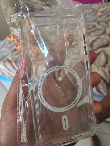 Customer holding the new Anti Yellow Magsafe Clear Case in its packaging, showing the white MagSafe ring on the transparent back.