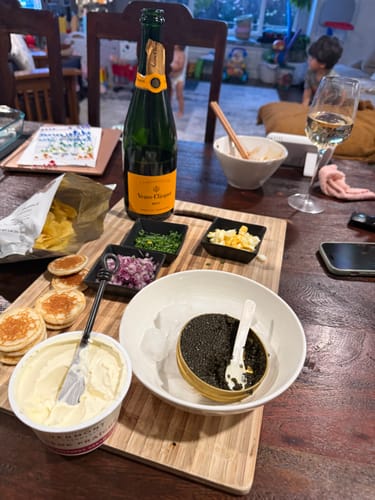 Reviewer enjoying a caviar spread at home, showing their protected package arrived safely.