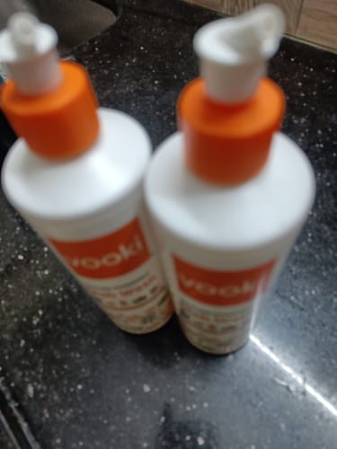 A customer's blurry photo of the two bottles of Nature Powered Dishwash Liquid on a dark countertop.