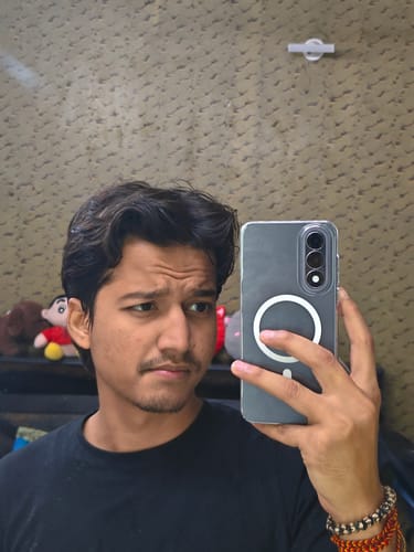 Reviewer taking a mirror selfie holding their phone in the clear Anti Yellow Magsafe case, showing the white MagSafe ring.