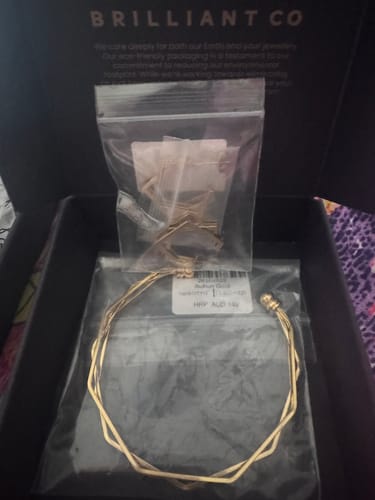 Reviewer's Oh My Gold Bangle and Earrings Set in the original packaging inside a black box.
