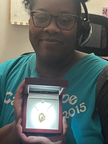 Customer holding the open 'To My Daughter' gift set, showing the beautiful necklace illuminated in its box.
