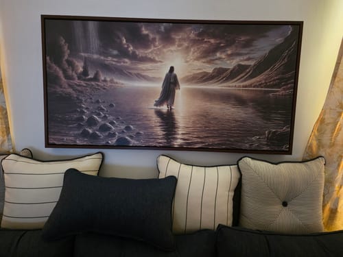 Customer's 'Walking on Water - Faith Wall Art II' hanging in their living room above a sofa with pillows.