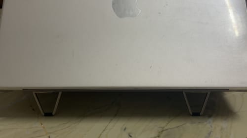 Customer's Casence AirStand for Laptop attached to the back of a silver laptop, providing a stable lift.