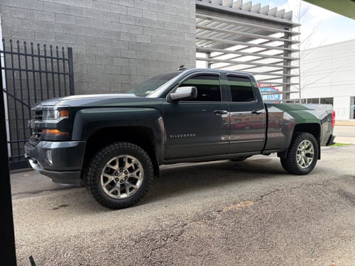 Customer's dark gray Silverado with the 3" lift kit installed, showing its raised stance from the side.